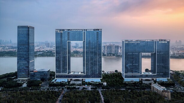 Three high-rise buildings with a central courtyard, surrounded by greenery and a body of water. - Crowne Plaza Guangzhou Window Of Canton by IHG (Guangzhou)