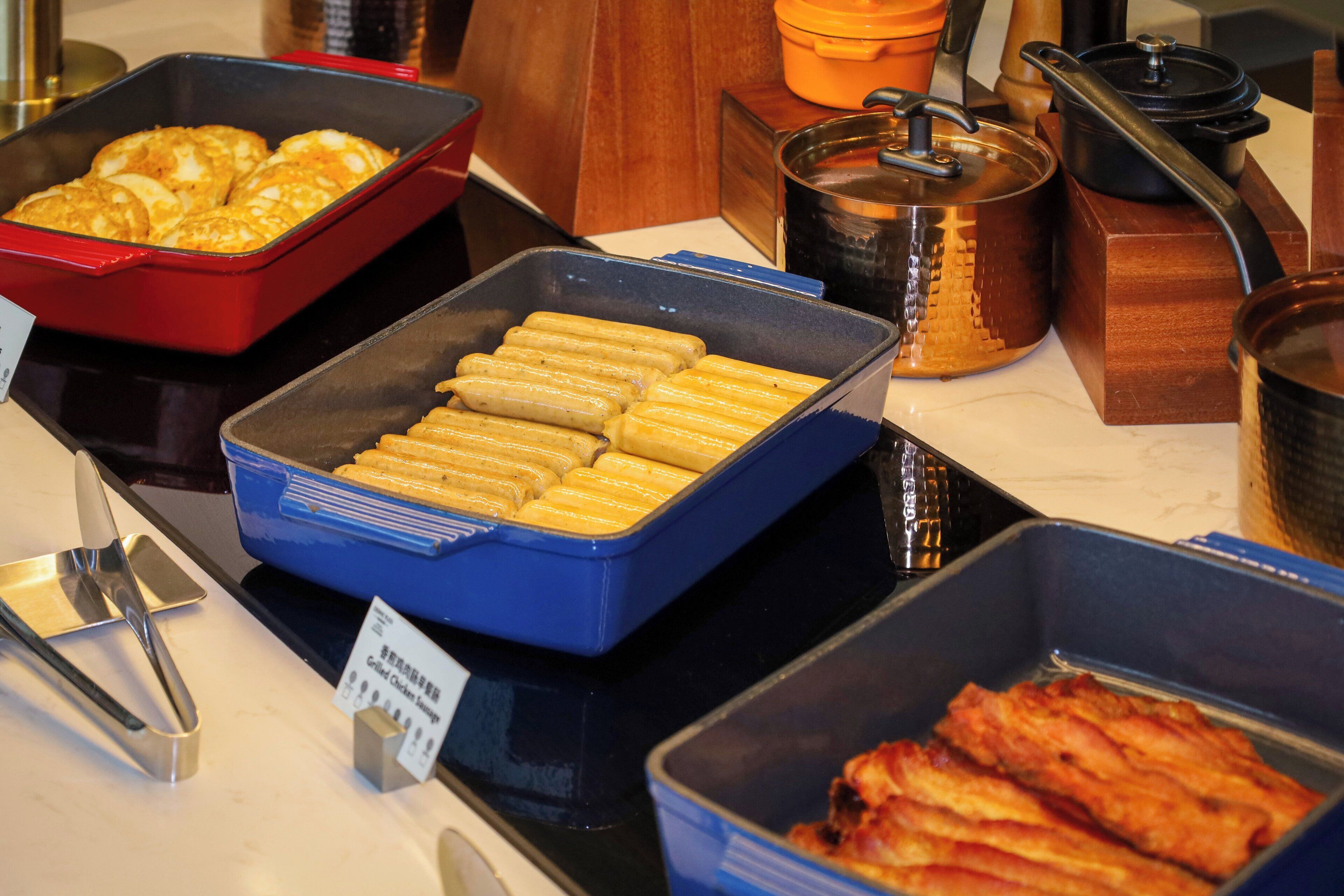A buffet with various food items including pastries, fried items, and a pot.