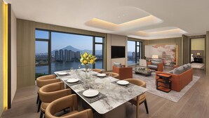 Un comedor moderno con una gran mesa, sillas y vistas a una ciudad y montañas.
