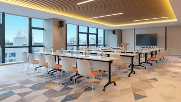 A modern conference room with large windows, a flat-screen TV, and a geometric patterned floor.