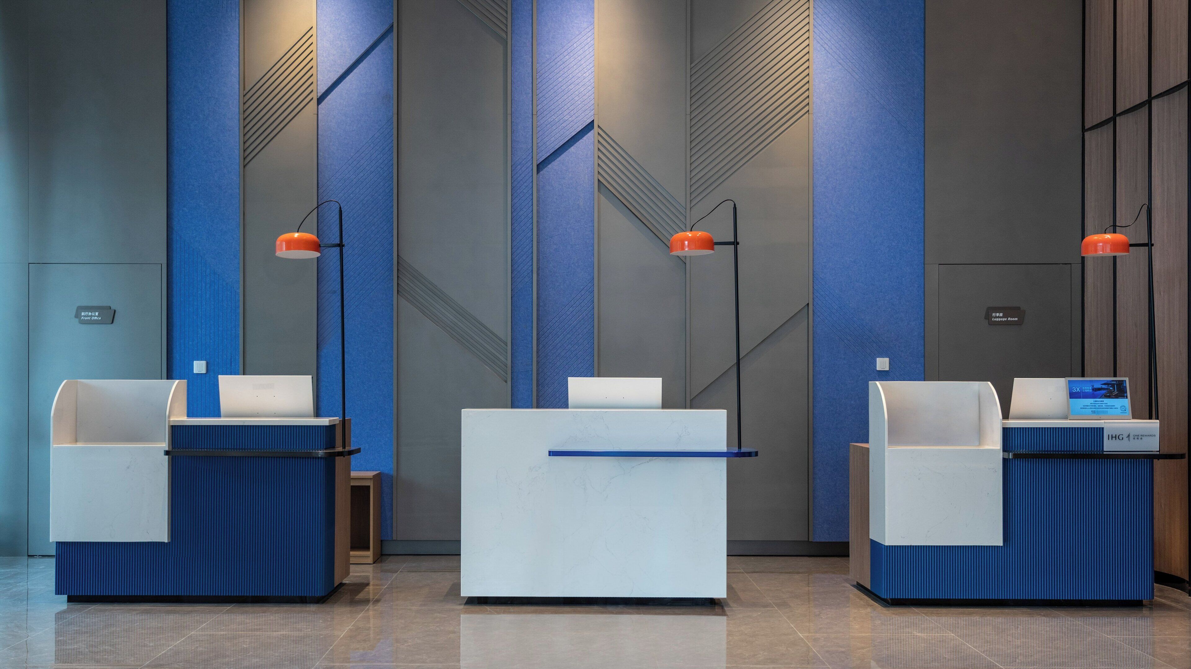 A reception area with three reception desks, a blue and grey color scheme, and a modern design.