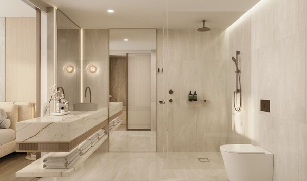 Un baño moderno con tocador de mármol, un espejo grande, ducha e inodoro.