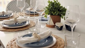 A dining table set with plates, glasses, and a potted plant. - Avalon Beach Condo (Avalon)