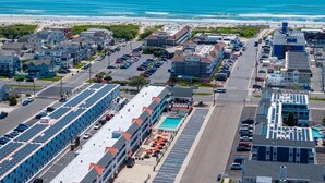 An aerial view of a coastal town with a hotel featuring a rooftop pool and a parking lot. - Avalon Beach Condo (Avalon)