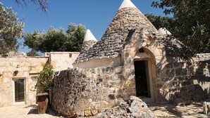 Un edificio de piedra con techo cónico y un arco de entrada.