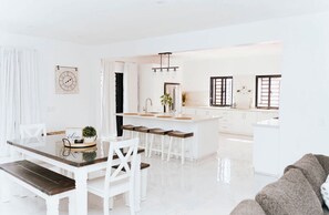 Enjoy meals and relaxation in this stylish kitchen with a central island, dining table, and comfortable seating area.
