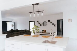 Enjoy cooking in this well-equipped kitchen with a central island and pendant light fixture.
