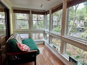 Enjoy a peaceful view of the surrounding neighborhood from the large window in this inviting room.