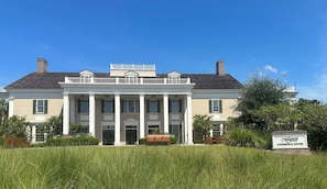 Stately building with a neoclassical facade, featuring a central entrance and columns supporting a balcony.
