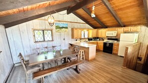 Una cocina rústica con armarios de madera, una isla central y una zona de comedor con un banco.