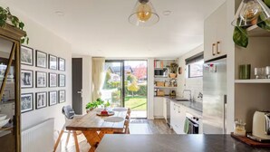 Una cucina moderna con zona pranzo, ampie finestre e vista sull'esterno.