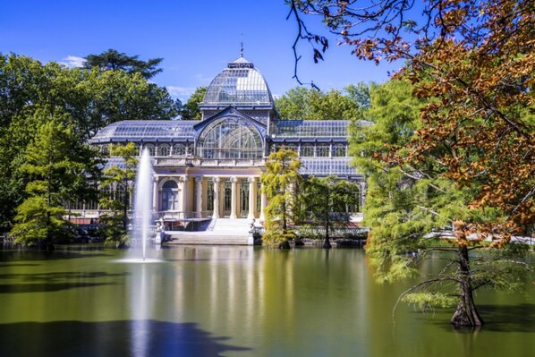 A large glass-domed building with a fountain in front, surrounded by trees and a body of water. - CRUZ APARTMENT FOR 6 PEOPLE (CANALEJAS) (Madrid)