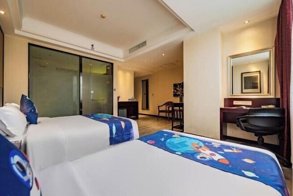 Relax in a stylish room with two single beds, a desk, and a balcony with a sliding glass door.