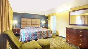 A hotel room with a bed, two bedside tables with lamps, a dresser, a mirror, and a door. - Bama Motel Mobile I-65 & US-90 (Mobile)