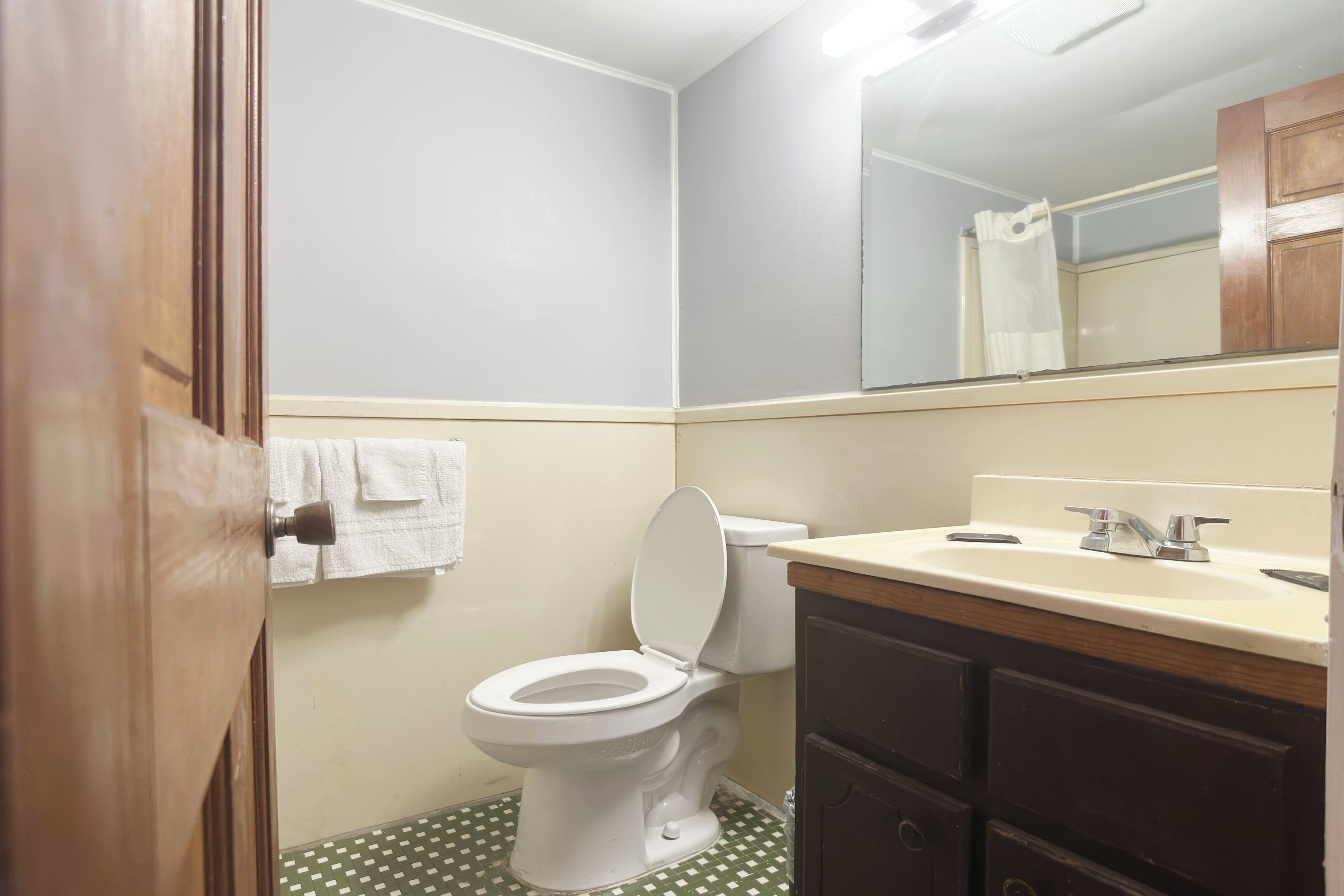 Un baño con inodoro, lavabo y espejo.