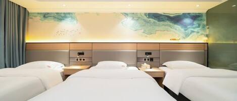 A hotel room with two beds, a marble wall, and a nightstand with a lamp.