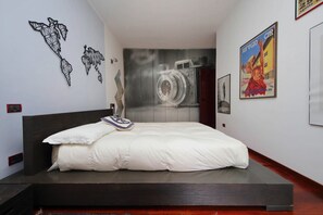 A modern bedroom with a large bed, a wall map, a wall-mounted camera, and a poster. - Rome, characteristic apartment for 5 close to the Vatican (Roma)
