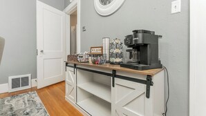 Et tekøkken med kaffemaskine, en kurv og et skilt med teksten 'Coffee'.