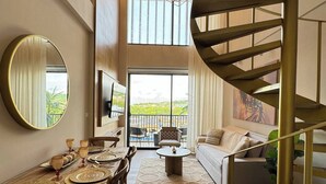 Un interno moderno con zona pranzo, divano e scala a chiocciola.