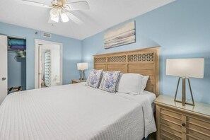 A bedroom with a large bed, a wooden headboard, two bedside lamps, and a ceiling fan. - Sundestin 510 (Destin)
