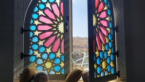 A room with a large arched window featuring intricate stained glass.