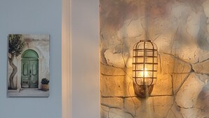A wall with a stone texture and a framed artwork depicting a green door.
