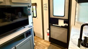 A compact RV kitchen with a microwave, oven, and a small sink. - Camper in Zephyrhills with Wi-Fi (Zephyrhills)