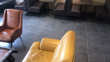 A seating area with leather sofas and tables, arranged in a casual layout.