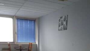 A room with two beds, a small table, and a chair. - Appart Hotel (Champagne-sur-Oise)