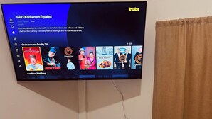 A flat-screen TV displaying a menu for the TV series "Hell's Kitchen en Español" on a streaming platform.