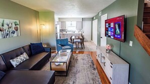 A modern living room with a sofa, coffee table, and a TV mounted on the wall. - Riverside Retreat Near 5 Points (Nashville)