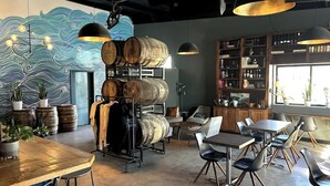 A restaurant interior with a rustic decor, featuring wooden barrels, a mural, and a variety of seating arrangements. - Riverside Retreat Near 5 Points (Nashville)