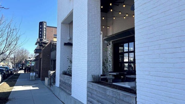 A building with a brick facade and a white brick exterior. There is a sign on the building that reads "EAST". - Riverside Retreat Near 5 Points (Nashville)