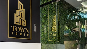 Ein moderner Gebäudeeingang mit Glasfassade und einer Marmortreppe, sowie das Logo für 'Menesse Condos Town Tower'.