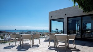 Eine Terrasse mit Sitzgelegenheiten und Meerblick.