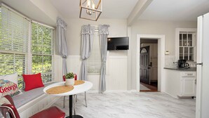 A modern kitchen with white cabinets, a built-in oven, and a countertop with a coffee maker.
