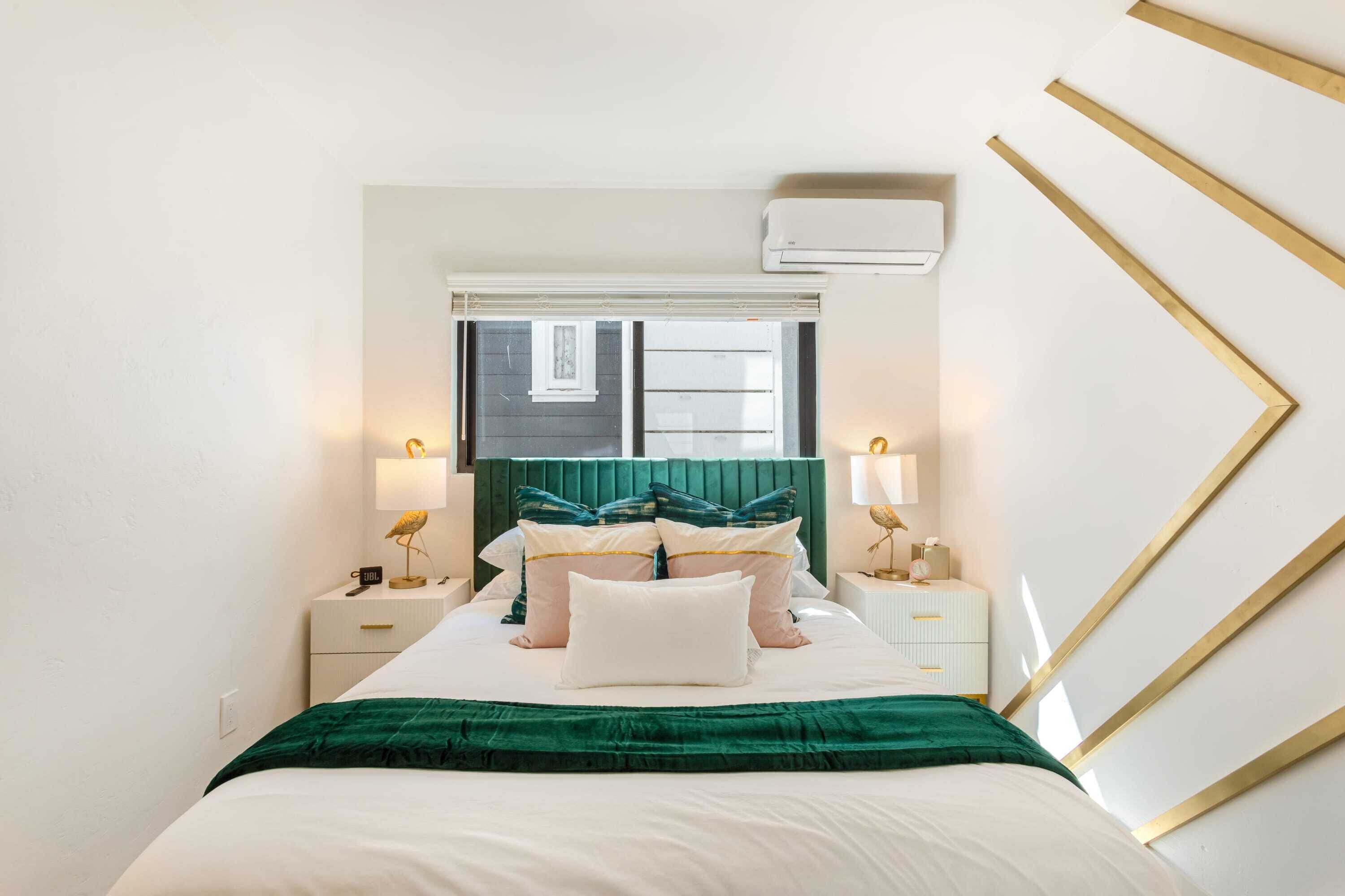 A neatly arranged bedroom with a bed, bedside tables, lamps, and a window.