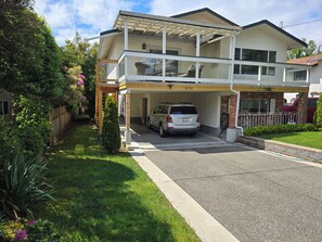 A two-story house with a covered garage and a car parked inside. - Furnished 1900sf 3bedr house in downtown Sidney one block from Ocean and shops (Sidney)