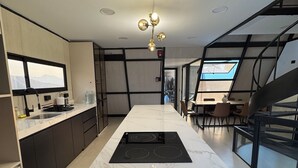 A modern kitchen with a central island, black cabinets, and a large window. - Only 30 min from Trujillo: Luxury retreat in the mountains ideal for disconnecting (Simbal)