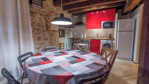 Une cuisine rustique avec des meubles de couleur rouge, un four à micro-ondes et un réfrigérateur blanc.