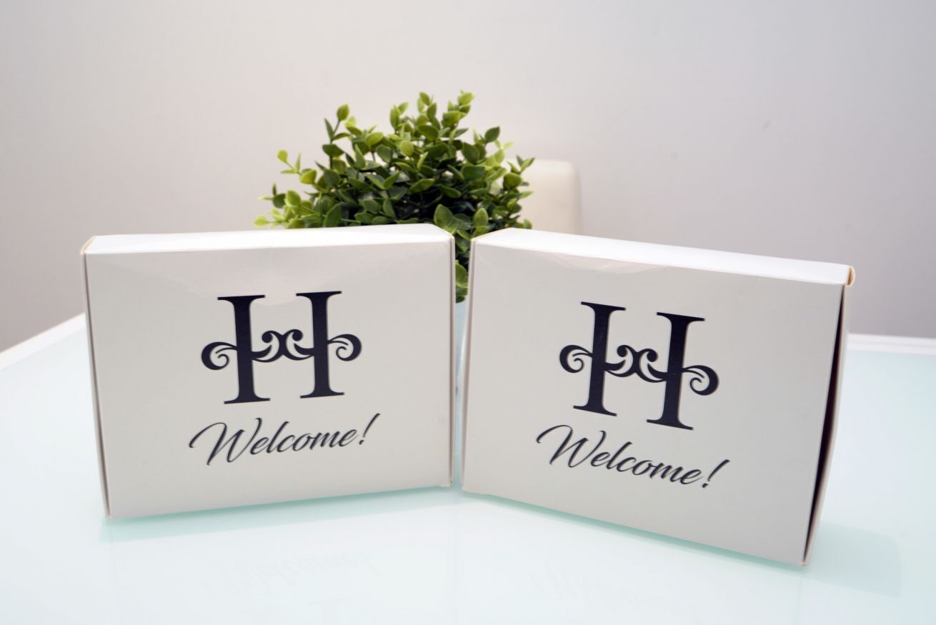 Two white welcome signs with a large 'H' and the word 'Welcome!' in cursive.