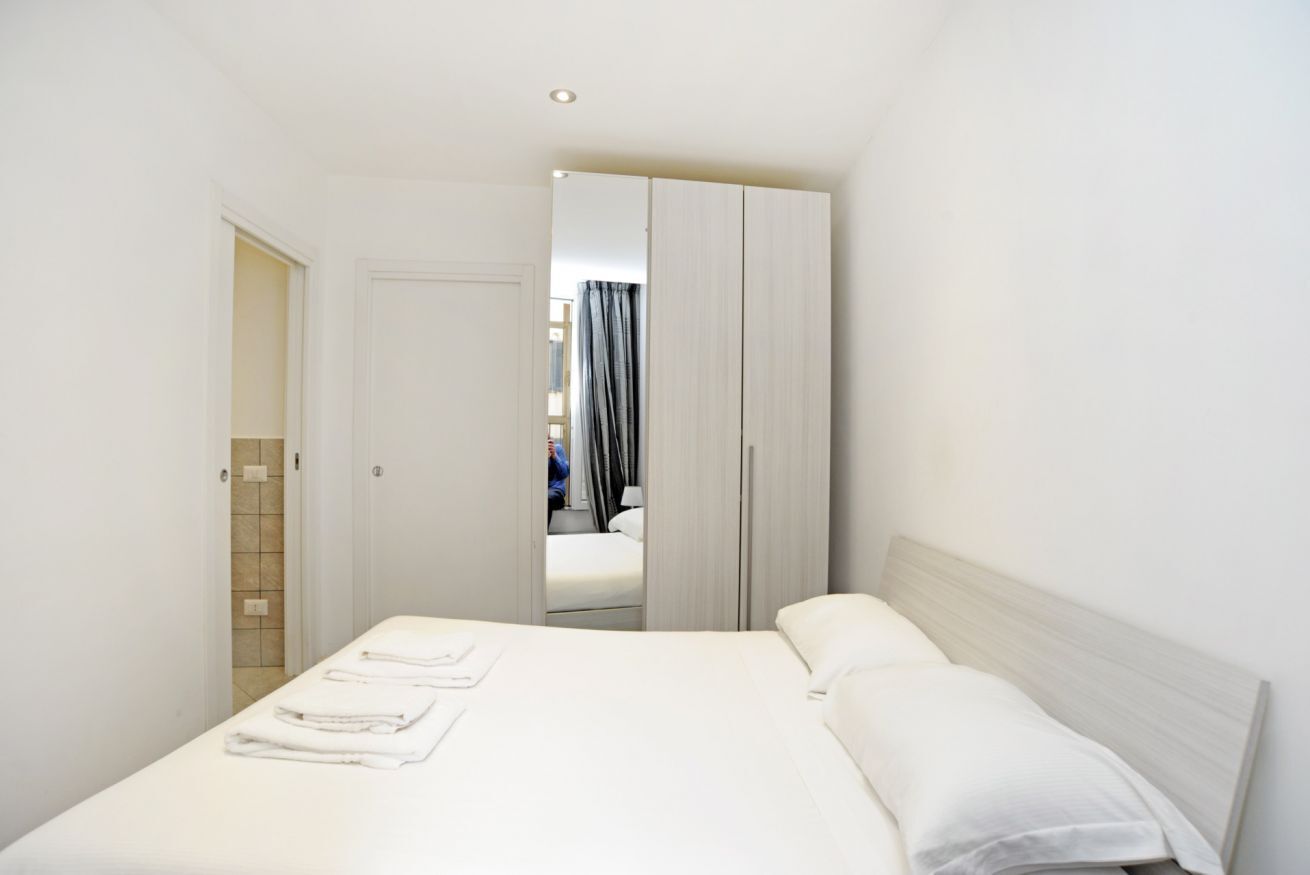 Een hotelkamer met een bed, een kledingkast en een badkamer.