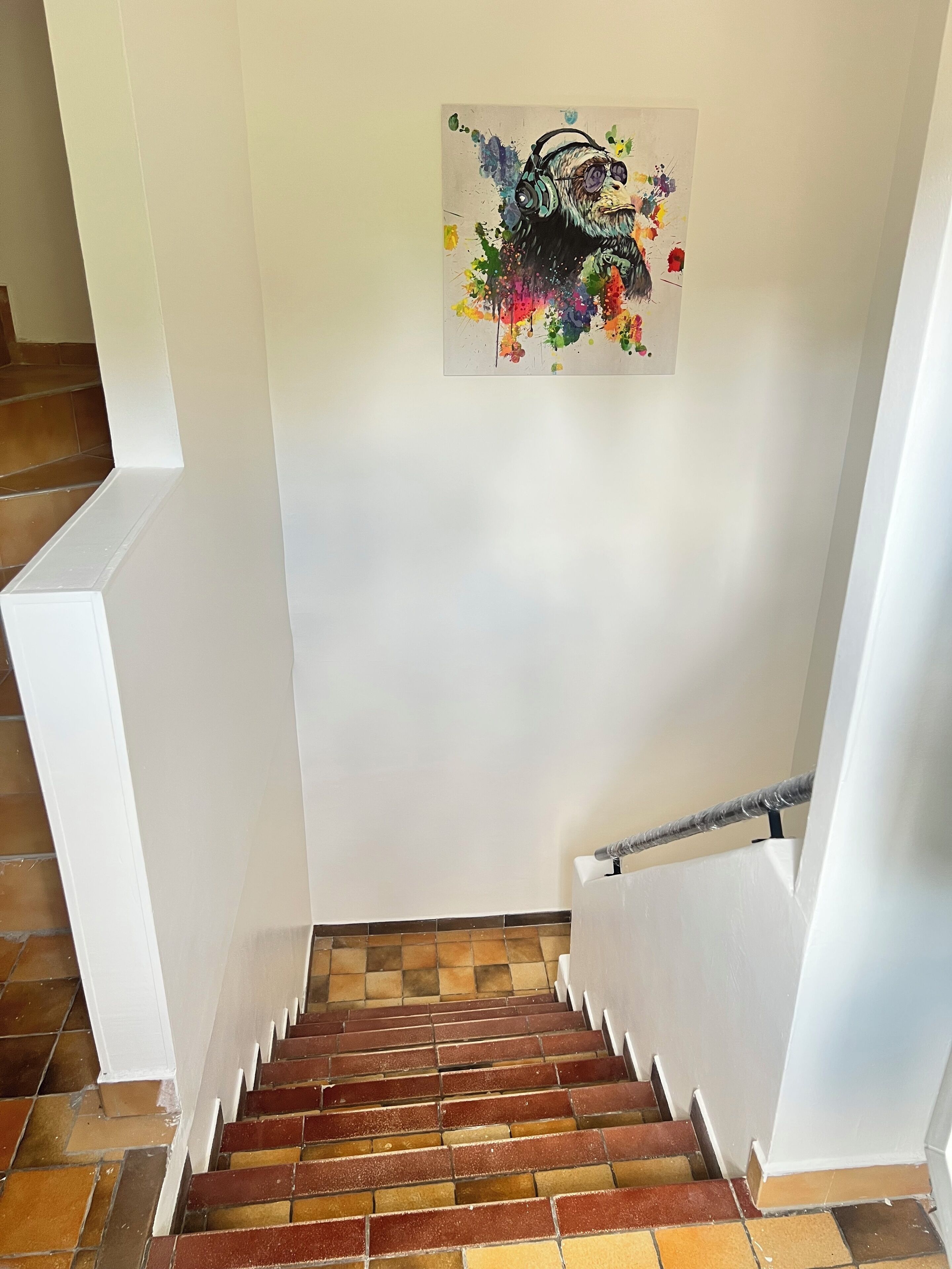 Eine Treppe mit einem farbenfrohen, abstrakten Gemälde an der Wand.