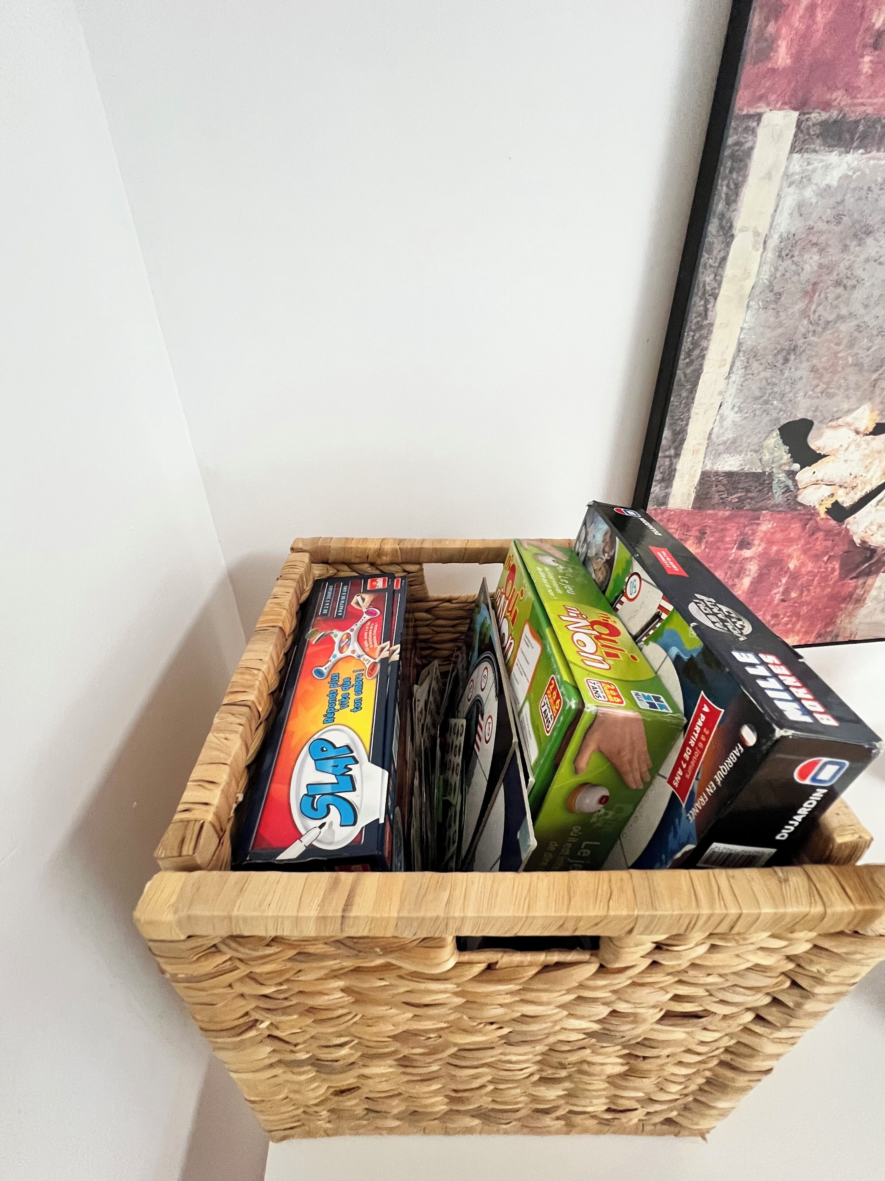 Een houten mand gevuld met verschillende spelletjes.