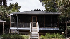 A wooden cabin with a porch and a staircase leading to the entrance. - Welcome to Rainbow at Folly House – Your Beachside Retreat Near Charleston! (Folly Beach)