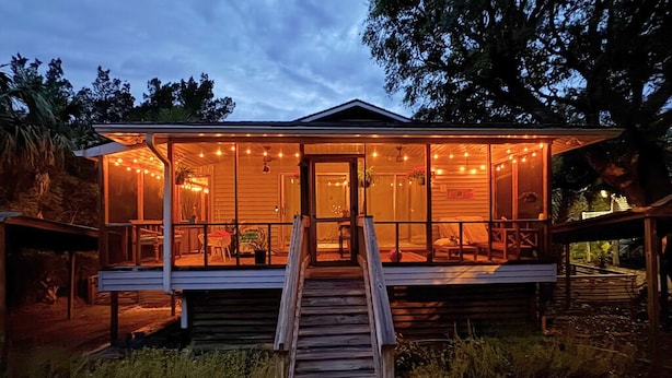A wooden cabin with a covered porch and a wooden staircase leading to the entrance. - Welcome to Rainbow at Folly House – Your Beachside Retreat Near Charleston! (Folly Beach)