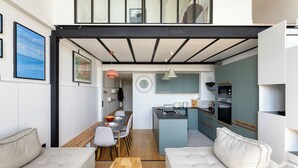 A compact living space with a dining area, kitchenette, and a sofa.