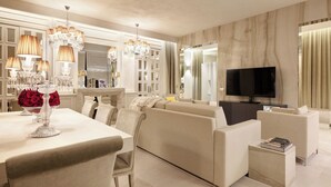 A modern living room with a sofa, a TV, and a dining area with a table and chairs. - Luxurious 3 Bedroom Apartment near Pantheon (Roma)