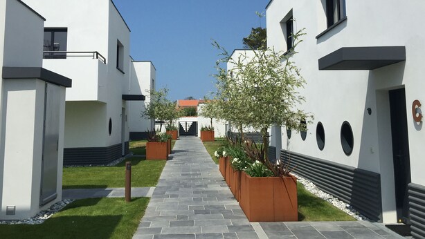 A modern building with a central pathway flanked by white walls and rectangular windows. - Villa Luxe 8p | Piscine & Plages à Pied (Anglet)