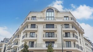 A multi-story building with balconies, large windows, and a dome-shaped structure on the top. - Studio cosy à 5 min du train direct pour Paris (Levallois-Perret)